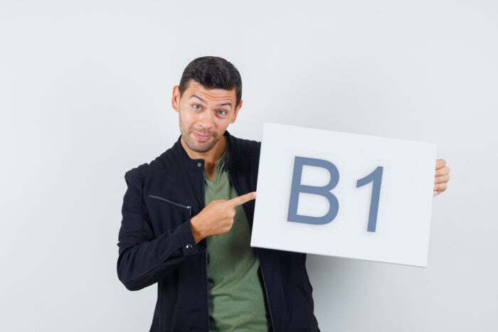 young male pointing at blank canvas in t shirt, jacket and looki